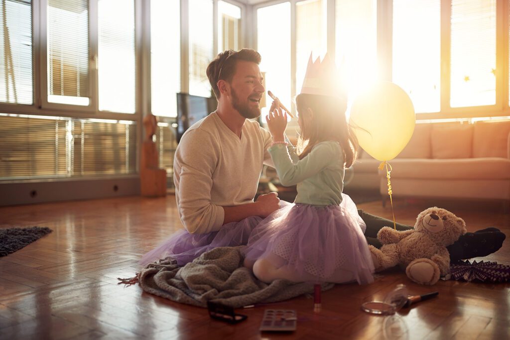 daughter and daddy playing dress-up together in living room